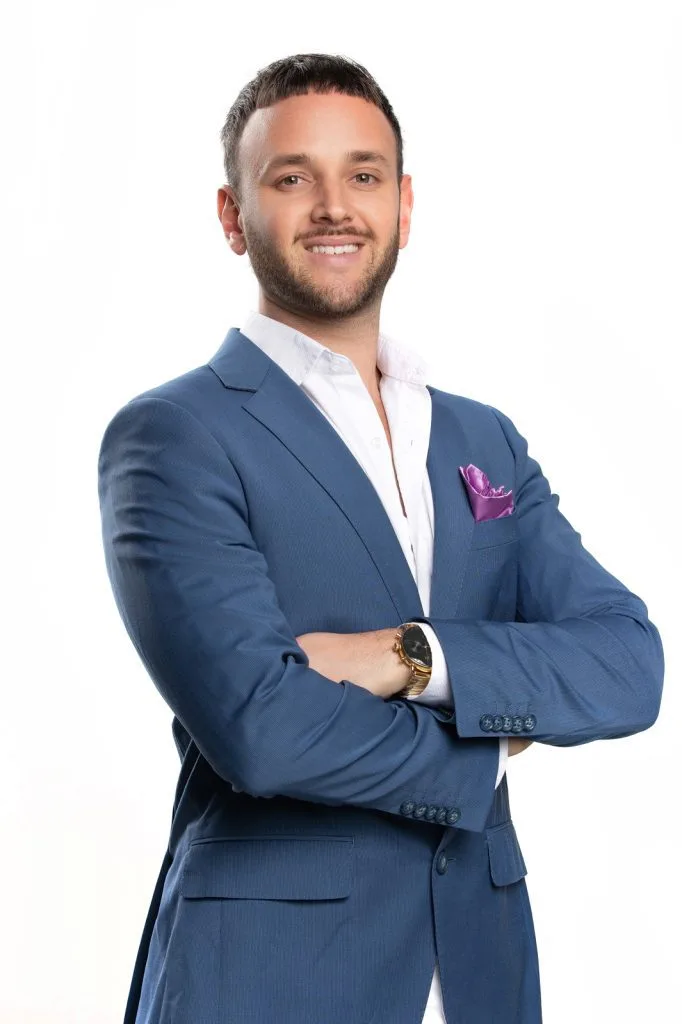 Man with folded arms on white background looking at camera